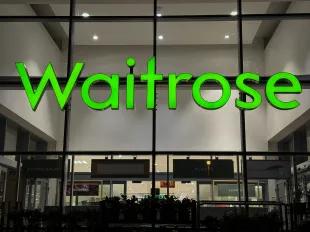 WELLS UNITED KINGDOM - NOVEMBER 05: The Waitrose logo is displayed outside a branch of the supermarket retailer Waitrose on November 5, 2023 in Wells, England. Founded in 1904, since 1937 it has been operated by employee-owned retailer John Lewis Partnership and is often described as having a upmarket reputation.