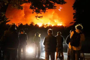 LOS ANGELES, CALIFORNIA - JANUARY 07: People watch the smoke and flames from the Palisades Fire in the Pacific Palisades neighborhood on January 07, 2025 in Los Angeles, California. Fueled by intense Santa Ana Winds, the Palisades Fire has grown to over 2,900 acres and 30,000 people have been ordered to evacuate while a second fire has emerged near Eaton Canyon. (Photo by Tiffany Rose/Getty Images)