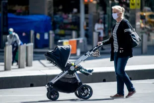 NEW YORK, NEW YORK - SEPTEMBER 22: A woman with a baby stroller wears a mask in Times Square during the fourth phase of the coronavirus reopening in Manhattan on September 22, 2020 in New York, New York. The fourth phase allows outdoor arts and entertainment, sporting events without fans and media production. (Photo by Roy Rochlin/Getty Images)