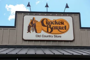 PEMBROKE PINES, FLORIDA - AUGUST 21: A Cracker Barrel sign featuring the old logo hangs on the outside of a restaurant on August 21, 2025 in Homestead, Florida. The restaurant unveiled a new logo earlier this week as part of a larger brand refresh. The new logo removes the image of a man sitting next to a barrel and the phrase “old country store”. Now the logo will feature the words “Cracker Barrel” against a yellow background. (Photo by Joe Raedle/Getty Images)