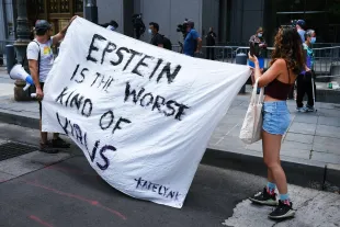 NEW YORK, NEW YORK - JULY 14:  People hold a banner protesting against Jeffrey Epstein while outside a Manhattan courthouse where media has gathered for the arraignment hearing of Ghislaine Maxwell on July 14, 2020 in New York City. Maxwell, the British socialite, longtime girlfriend and alleged accomplice of deceased, accused sex-trafficker Jeffrey Epstein, was recently arrested in New Hampshire and is charged by New York federal prosecutors with six counts in connection with the ongoing federal investigation into Epstein's accomplices. Calling her a flight risk, prosecutors want Maxwell, 58 and who will appear at the hearing via a video link, remanded. (Photo by Spencer Platt/Getty Images)