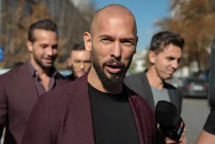 BUCHAREST, ROMANIA - OCTOBER 15: Andrew Tate talks to the media outside the Court of Appeal on October 15, 2024 in Bucharest, Romania. Social Media Influencer Andrew Tate and his brother Tristan are appearing in court to appeal a decision to proceed with their trial on charges of rape, human trafficking and forming a criminal gang to exploit women. The Tate brothers were arrested on December 29, 2022, alongside Georgiana Naghel and Luana Radu as part of an investigation into human trafficking and rape. (Photo by Andrei Pungovschi/Getty Images)
