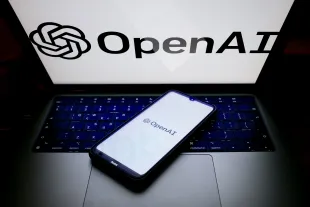The OpenAI logo is being displayed on a smartphone screen and on a computer screen in Athens, Greece, on May 21, 2024. (Photo by Nikolas Kokovlis/NurPhoto via Getty Images)