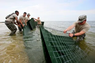 National Guard 711 Brigade Support Batallion install barriers on the inside shore of the Dauphin Islands. The barriers will be filled with polymers that turn any oil spill into a rubberlike solid. (Photo by Orjan F. Ellingvag/Dagens Naringsliv/Corbis via Getty Images)
