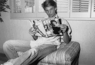 American actor Steve Burton reading a copy of '16' magazine sitting beneath a jalousie window, March 1988.  (Photo by Vinnie Zuffante/Getty Images)
