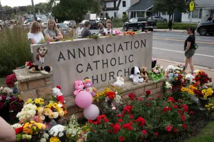 People leave flowers and other mementoes in front of Annunciation Catholic Church, a rapidly growing memorial to the victims of yesterday's shooting on August 28, 2025 in Minneapolis, Minnesota. (Photo by Scott Olson/Getty Images)