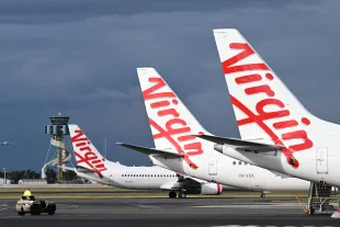 SYDNEY, AUSTRALIA - JUNE 24: Virgin Australia Boeing 737 aircraft at Sydney Airport on June 24, 2025 in Sydney, Australia. Virgin Australia is the country's second largest airline group, focused on delivering great value and choice to approximately 20 million passengers annually. Revitalised under the ownership of Bain Capital, Virgin Australia is a value carrier which operates a fleet of more than 100 aircraft on 76 routes to 38 destinations across its domestic and short-haul international airline business. The airline has a world class suite of international airline partners which enable its customers to fly to over 650 destinations globally, and last week commenced its own long-haul international services between Australia and Doha through a wet lease with Qatar Airways. Virgin Australia's airline business is supported by the award-winning loyalty program Velocity, which has approximately 80 commercial partners and approximately 13 million members, making it one of the largest loyalty programs in the country. (Photo by James D. Morgan/Getty Images for Virgin Australia )