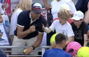 Piotr Szczerek stealing Kamil Majchrzak's cap from the boy (Image via YouTube/@CBCTheNational)