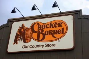 A Cracker Barrel sign featuring the old logo hangs outside of a restaurant on August 27, 2025 in Florida City, Florida (Image via Getty)