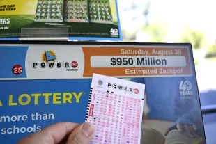 CALIFORNIA, UNITED STATES - AUGUST 28: A Powerball lottery ticket and a monitor are seen as U.S. Powerball jackpot grows $950 million, in Foster City, California, United States on August 28, 2025. (Photo by Tayfun Coskun /Anadolu via Getty Images)