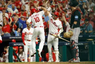 PHILADELPHIA, PENNSYLVANIA - OCTOBER 04: J.T. Realmuto #10 celebrates with Nick Castellanos #8 of the Philadelphia Phillies after hitting a solo home run during the fourth inning against the Miami Marlins in Game Two of the Wild Card Series at Citizens Bank Park on October 04, 2023 in Philadelphia, Pennsylvania. (Photo by Sarah Stier/Getty Images)