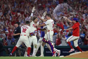 Philadelphia Phillies celebrate after the game-winning hit to defeat the New York Mets in Game Two of the Division Series at Citizens Bank Park on October 06, 2024 in Philadelphia, Pennsylvania. (Photo by Hunter Martin/Getty Images)