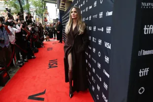 Angelina Jolie revisits her 2012 Oscars moment with a striking slit-coat look at the 2025 TIFF red carpet.