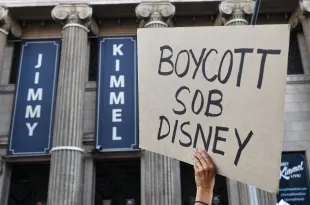 LOS ANGELES, CALIFORNIA - SEPTEMBER 18: A person holds a sign reading "Boycott SOB Disney" as demonstrators protest the suspension of the "Jimmy Kimmel Live!" show outside the El Capitan Entertainment Centre where the show is performed in Hollywood on September 18, 2025 in Los Angeles, California. Kimmel's ABC late-night show has been "indefinitely" taken off the air following controversy over his comments about the killing of Charlie Kirk. (Photo by Mario Tama/Getty Images)