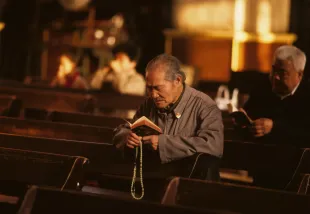 A Catholic worshiper reads a bible. (Photo by Forrest Anderson/Getty Images)