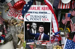 A pile of flowers, candles, and photos placed outside the original Turning Point USA office in Lemont, founded by Charlie Kirk, on Sunday, September 21, 2025, marking the day of his funeral in Illinois, United States. (Photo by Jacek Boczarski/Anadolu via Getty Images)