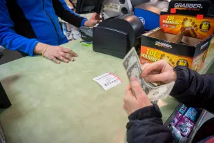 A woman buys a chance to win the $1.5 billion Powerball jackpot on Wednesday, January 13, 2016. The jackpot has rolled over 18 times with no winner, with the next drawing today at 10:59 PM EST. (�� Richard B. Levine) (Photo by Richard Levine/Corbis via Getty Images)