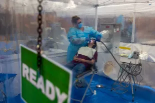 TERRE HAUTE, INDIANA - AUGUST 02: Dentists care for patients at a Remote Area Medical (RAM) mobile dental and medical clinic at Terre Haute South High School on August 02, 2025 in Terre Haute, Indiana. More than a thousand people are expected to seek free dental, medical, and vision care at the two-day event in Terre Haute, which has a poverty rate of over 25 percent. Non-profit organization RAM provides free medical care through mobile clinics in underserved, isolated, or impoverished communities around the country and world. As healthcare continues to be a contentious issue in the U.S., an estimated 27 million people — or 8.3 percent of the population — are uninsured, according to a report from the Census Bureau, with the rate considerably higher in rural and poorer parts of the country. (Photo by Spencer Platt/Getty Images)