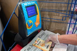 South Pasadena, CA - October 01:   A woman checks to see if she won the Mega Millions lottery at Foremost Liquor Store on Sunday, Oct. 1, 2023, in South Pasadena, CA. The Powerball lottery has reached the 1 billion mark with an estimated $1.04 billion jackpot, for the next drawing on Monday night after no grand prize winner in Saturday's drawing.  (Francine Orr / Los Angeles Times via Getty Images)
