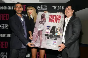 Taylor Swift is honored by Universal Music Group UK CEO and Chairman David Joseph (L) and Big Machine Label Group President and CEO Scott Borchetta (R) for her multi-platinum album RED at a special event during the final 3 nights of her sold-out North American tour on September 19, 2013 at the Bridgestone Arena in Nashville, Tennessee.  (Photo by Larry Busacca/TAS/Getty Images for TAS)