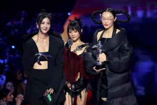 ELMONT, NEW YORK - SEPTEMBER 07: (L-R) EJAE, REI AMI and Audrey Nuna of HUNTR/X from ‘KPop Demon Hunters’ speak onstage during the 2025 MTV Video Music Awards at UBS Arena on September 07, 2025 in Elmont, New York. (Photo by Manny Carabel/Getty Images for MTV)