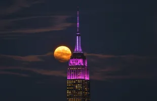 UNION CITY, NJ - SEPTEMBER 17: The full Harvest Supermoon rises behind the Empire State Building in New York City on September 17, 2024, as seen from Union City, New Jersey.  (Photo by Gary Hershorn/Getty Images)