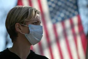NEW ROCHELLE,  NY - MARCH 18:  Coronavirus crisis volunteer Rhiannon Navin greets local residents arriving to a food distribution center at the WestCop community center on March 18, 2020 in New Rochelle, New York. New Rochelle has been a hot spot for the COVID-19 pandemic in the U.S.  (Photo by John Moore/Getty Images)