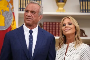 WASHINGTON, DC - FEBRUARY 13: Robert F. Kennedy Jr. and his wife Cheryl Hines listen as U.S. President Donald Trump speaks before Kennedy is sworn in as Secretary of Health and Human Services in the Oval Office at the White House on February 13, 2025 in Washington, DC. Kennedy, who faced criticism for his past comments on vaccine, was confirmed by the Senate 52 to 48. Former Senate Republican Leader Mitch McConnell (R-KY) was the only Republican to vote against him.  (Photo by Andrew Harnik/Getty Images)