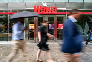 WASHINGTON, DC - MAY 29: People walk past a Wawa store on May 29, 2024 in Washington, DC. The convenience store and gas station chain, which has its origins in Pennsylvania, recently opened its first store in North Carolina, with 10 more expected across the state this year. It aims to open up to 100 new stores each year, reaching 2,000 stores by 2030. (Photo by Kent Nishimura/Getty Images)