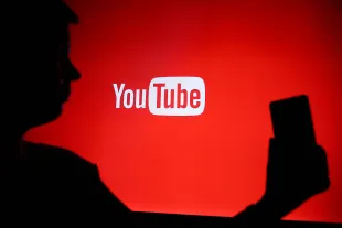 A person holds a phone displaying the YouTube logo in Knurow, Poland, on April 20, 2025. (Photo Illustration by Klaudia Radecka/NurPhoto via Getty Images)