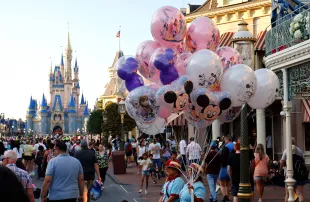 A vendor sells balloons along Main Street in front of Cinderella's Castle as the sun sets at the Magic Kingdom Park at Walt Disney World on May 31, 2024, in Orlando, Florida. (Photo by Gary Hershorn/Getty Images)