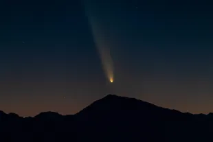 BIG PINE, CALIFORNIA - OCTOBER 12: Comet Tsuchinshan-ATLAS appears over the Eastern Sierra mountains as it transitions into the evening sky shortly after sunset, as seen from the Ancient Bristlecone Pine Forest area, on October 12, 2024 near Big Pine, California. The coma, or comet head, measures approximately 130,000 miles (209,000 kilometers) in diameter and the tail stretches out for about 18 million miles (29 million km). The comet will not return for another 80,000 years.   (Photo by David McNew/Getty Images)