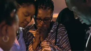 Family and community members gather in mourning in a scene from The Perfect Neighbor on Netflix, highlighting the impact of Ajike “AJ” Owens’ death. Image via Netflix.