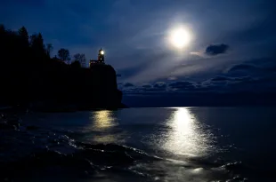 A bright moon shone over the horizon near the Split Rock Lighthouse on November 10, 2019. It was lit to honor the lives of the 29 men that died aboard the Edmund Fitzgerald 44 years ago. The lighthouse is only lit for approximately two hours and fifteen minutes each year. (Photo by Alex Kormann/Star Tribune via Getty Images)
