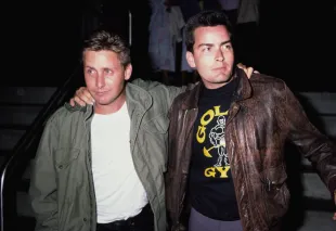 American actors Emilio Estevez, wearing a green M65 field jacket, with his brother Charlie Sheen, wearing a Type A-2 leather flight jacket and Gold's Gym t-shirt, at the premiere of John Badham's 'Stakeout', 1987. (Photo by Vinnie Zuffante/Getty Images)