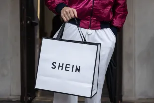 MILAN, ITALY - APRIL 17: A man holds a bag as he leaves the SHEIN’s “Spring Boutique” temporary store at Palazzo dei Giureconsulti on March 23, 2024 in Milan, Italy. SHEIN, a Chinese e-commerce platform specialized in ultra fast fashion, frequently holds temporary "pop-up" stores to allow customers to experience their products in person and to interact with the brand offline. (Photo by Emanuele Cremaschi/Getty Images)