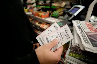 CHICAGO, IL - JANUARY 9 : A customer shows off his Powerball tickets at a 7-Eleven store January 9, 2016 in Chicago, Illinois. The Powerball Jackpot Surged to a record $900 Million in 44 States, Washington D.C., Puerto Rico, and the US Virgin Islands before tonight's drawing. (Photo by Joshua Lott/Getty Images)