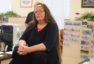 Kim Davis, the Rowan County Clerk of Courts, listens to Robbie Blankenship and Jesse Cruz (Image via Getty)