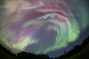 MINNESOTA, UNITED STATES - AUGUST 12: (EDITORS NOTE: This image was shot with a fisheye lens.) The northern lights (Aurora Borealis) illuminates the sky as a geomagnetic storm is bringing vibrant green and pink colors, during the peak of the Perseid meteor shower in Aitkin, Minnesota, United States on August 12, 2024. (Photo by Christopher Mark Juhn/Anadolu via Getty Images)