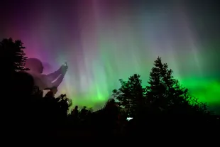 LATOURELL, OREGON - MAY 11: Onlookers gaze upon and photograph the Northern Lights at Chanticleer Point Lookout on the Columbia River Gorge in the early morning hours of May 11, 2024 in Latourell, Oregon. Places as far south as Alabama and parts of Northern California were expected to see the aurora borealis, also known as the northern lights from a powerful geomagnetic storm that reached Earth. (Photo by Mathieu Lewis-Rolland/Getty Images)