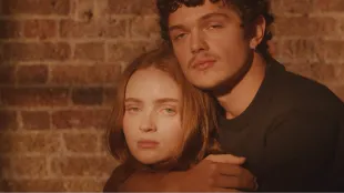 Sadie Sink and Noah Jupe as Juliet and Romeo in a warm, close-up promo portrait for the West End production of Romeo & Juliet. Image via romeojulietplay.com.