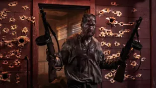 Aatami Korpi Jorma Tommila steps from a bullet riddled doorway carrying two PPSh 41 drum guns in Sisu: Road to Revenge. Image via Sony pictures.