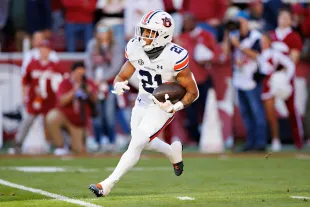 FAYETTEVILLE, ARKANSAS - NOVEMBER 11: Brian Battie #21 of the Auburn Tigers runs the ball during the game against the Arkansas Razorbacks at Donald W. Reynolds Razorback Stadium on November 11, 2023 in Fayetteville, Arkansas. The Tigers defeated the Razorbacks 48-10.  (Photo by Wesley Hitt/Getty Images)