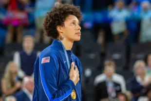 PARIS, FRANCE: AUGUST 11: A tear runs down the face of Brittney Griner #15 of Team United States while on the podium during the national anthem after the team's gold medal victory during the United States of America v France, Women's Basketball Gold Medal Game at the Bercy Arena during the Paris 2024 Summer Olympic Games on August 11th, 2024, in Paris, France. (Photo by Tim Clayton/Corbis via Getty Images)