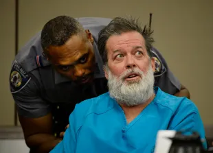 COLORADO SPRINGS, CO - DECEMBER 09:  An El Paso County Deputy asks defendant Robert Lewis Dear to keep quiet during a court appearance December 09, 2015 in Colorado Springs, Colorado. El Paso County prosecutors filed formal charges against Lewis in the November 27 Planned Parenthood attack in which University of Colorado Colorado Springs police officer Garrett Swasey, Iraq war veteran Ke'Arre  Stewart and Jennifer Markovsky, mother of two were killed.  (Photo by Andy Cross-Pool/Getty Images)