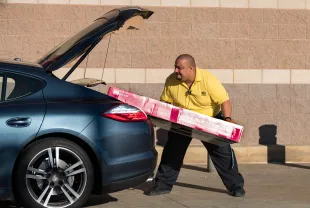 A Best Buy employee loads a TV into a customers car on Black Friday in Los Angeles, California on November 24, 2017. Black Friday occurs the day after Thanksgiving and kicks off the holiday shopping season, as retailers lure shoppers with reduced prices. (Photo by Ronen Tivony/NurPhoto via Getty Images)