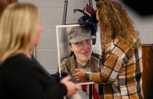 Community members prepare a portrait of West Virginia National Guard Specialist Sarah Beckstrom for a vigil in her honor at the town hall  (Image via Getty)