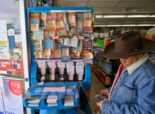 Garden Grove, CA - November 02: Alberto Lara checks for winning scratchers at the lottery station inside ABC Liquor in Garden Grove, CA, on Wednesday, November 2, 2022. The Powerball prize soared to $1.2 billion after no winners were found Monday. (Photo by Jeff Gritchen/MediaNews Group/Orange County Register via Getty Images)