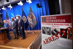 WASHINGTON, DC - DECEMBER 04: A poster is displayed during a press conference with Attorney General Pam Bondi and FBI Director Kash Patel about the January 6th pipe bomber at the Department of Justice on December 4, 2025 in Washington, DC. Federal agents have arrested a suspect they are charging with placing two pipe bombs, which never exploded, the night before the January 6th, 2021 U.S. Capitol attack. (Photo by Andrew Harnik/Getty Images)