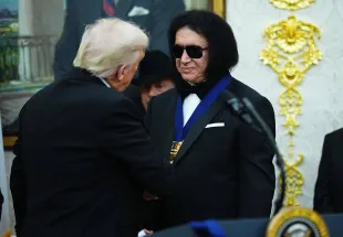 WASHINGTON, DC - DECEMBER 06: U.S. President Donald Trump (L) presents musician Gene Simmons (R) of the rock band KISS a medal for the 2025 Kennedy Center Honorees during a medal presentation in the Oval Office of the White House on December 06, 2025 in Washington, DC. The 2025 Kennedy Center honorees are Sylvester Stallone, George Strait, the rock band KISS, Gloria Gaynor, and Michael Crawford. (Photo by Aaron Schwartz/Getty Images)